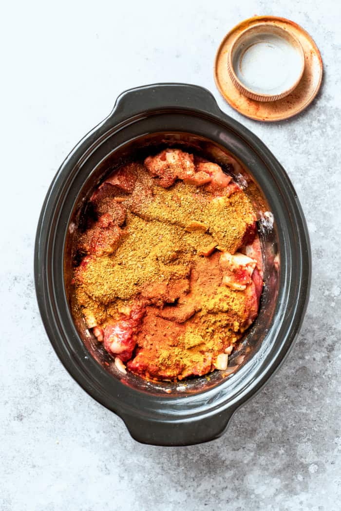 With fall-apart tender beef, fragrant spices, and a creamy coconut broth, this easy Slow Cooker Beef Curry is even better than takeout! Overhead view of beef curry in crockpot before cooking