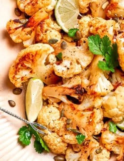 Mexican roasted cauliflower with pepitas on serving platter.
