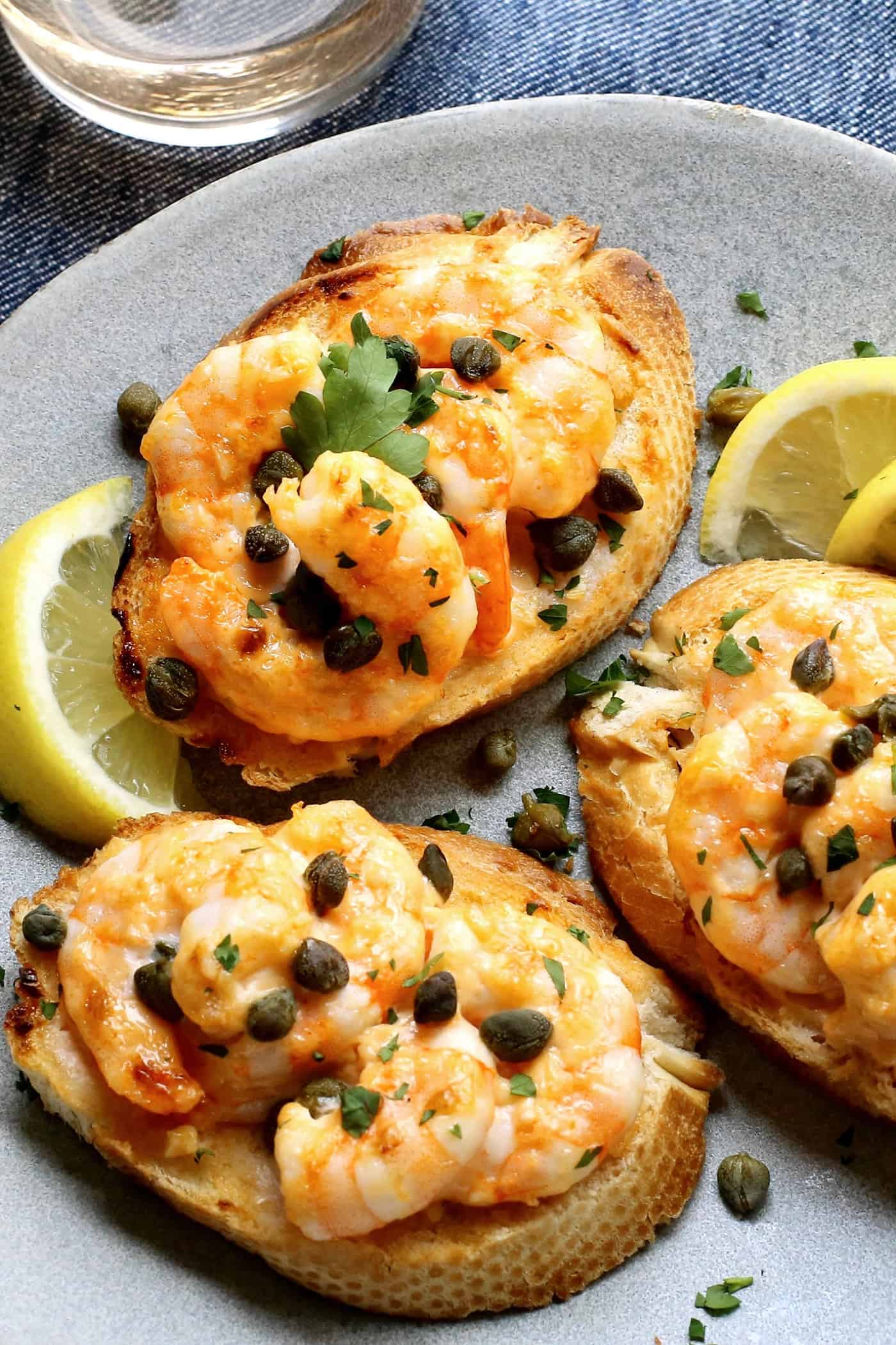 Sriracha garlic shrimp toast is made with tender shrimp, spicy sriracha mayo, and lightly crispy toast! An easy appetizer or light meal. Close-up of shrimp garlic toast.