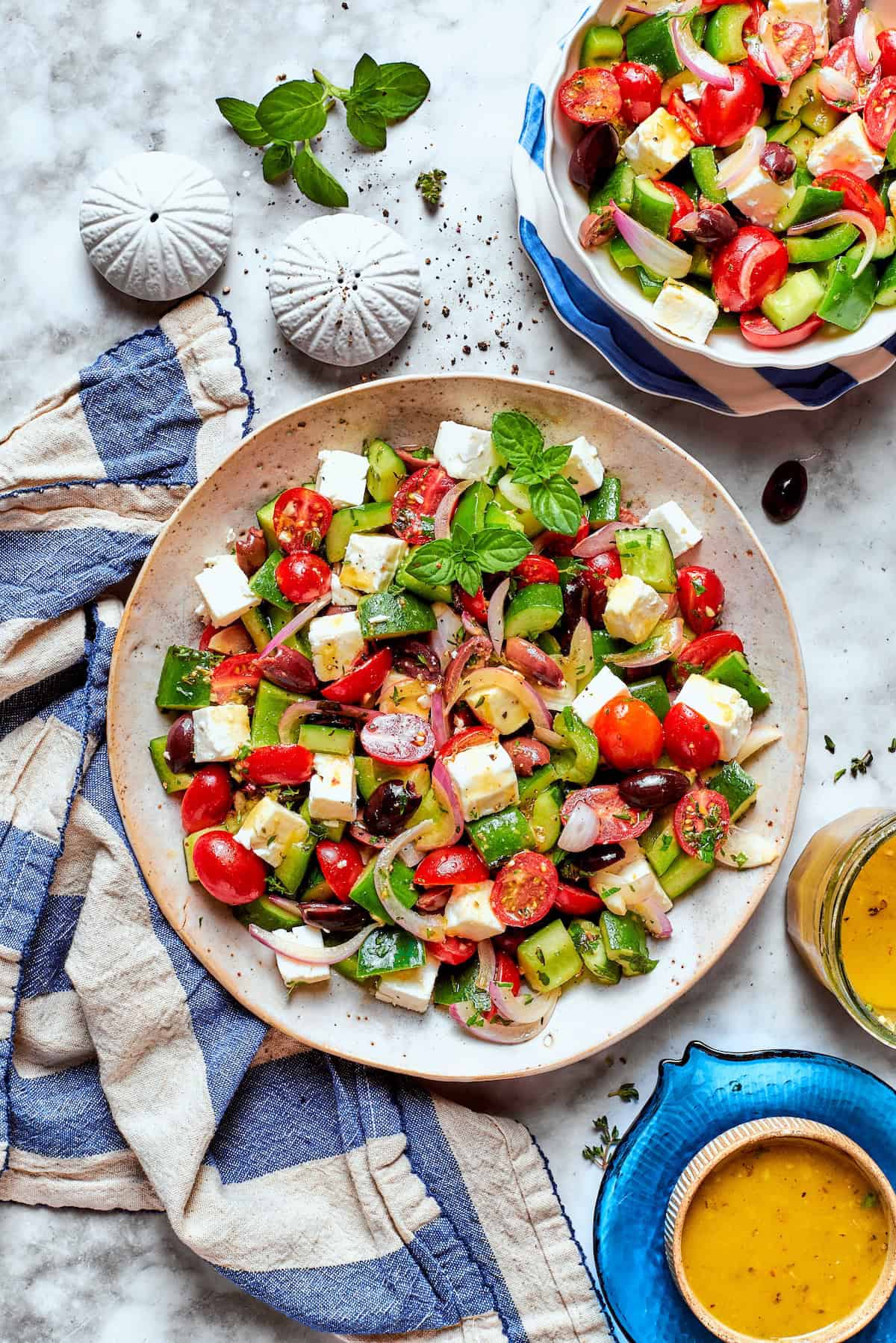 This Greek Chopped Salad is loaded with fresh cucumbers, tomatoes, bell peppers, and herbs and drizzled with a bright, flavorful dressing. Overhead view of Greek chopped salad in two bowls