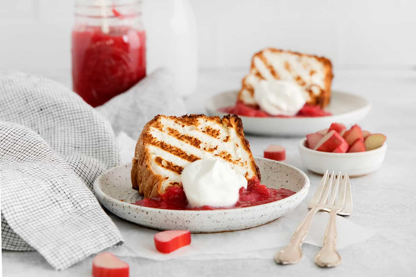 Grilled Angel Food Cake is a quick and easy way to elevate a simple angel food cake. Top with a sweet-tart rhubarb sauce and whipped cream, Grilled angel food cake with rhubarb sauce and whipped cream