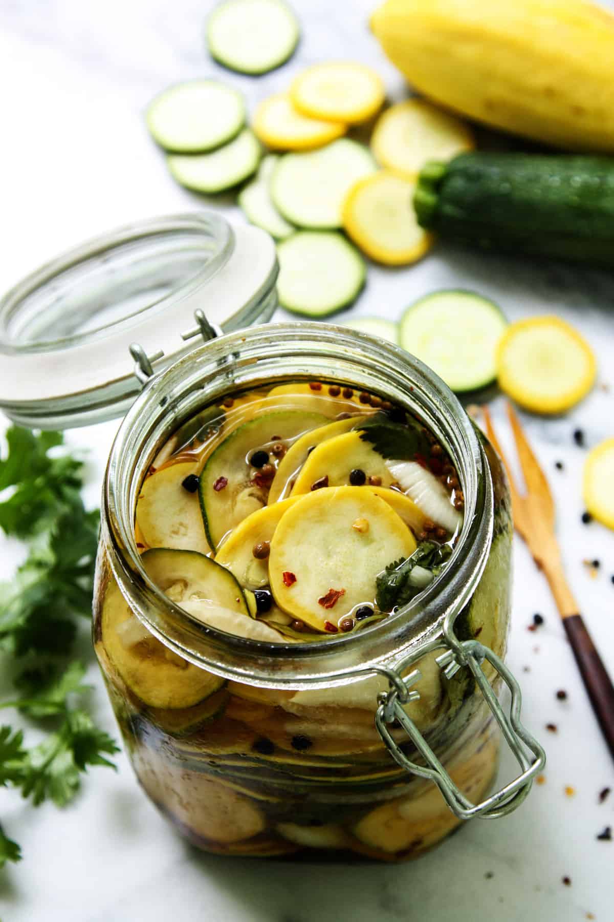This sweet-and-savory pickled squash recipe with red pepper flakes, cilantro, and sweet onions is an easy homemade condiment. Homemade pickled squash recipe with peppercorns, coriander seeds, onions, and tangy brine.