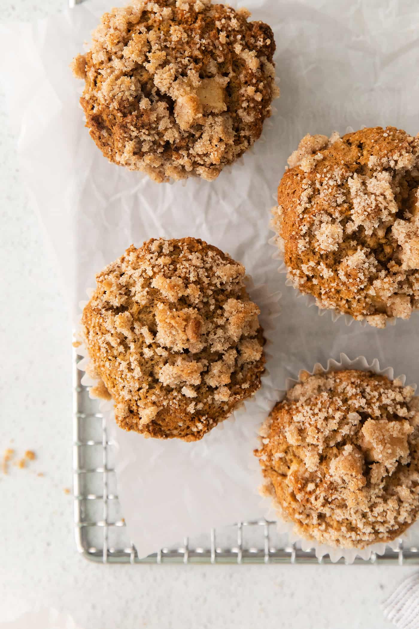 Make moist, tender apple muffins studded with juicy apple bites! Topped with cinnamon streusel, these easy muffins are great for fall baking. Overhead view of apple muffins with crumb topping