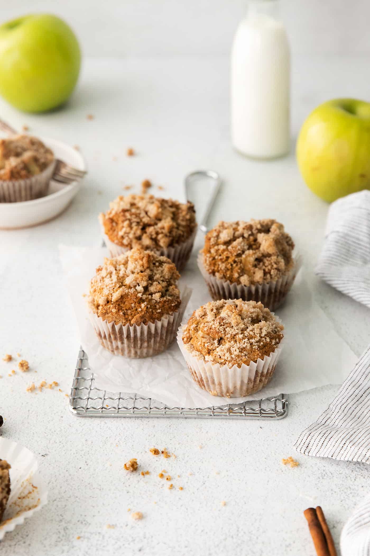 Make moist, tender apple muffins studded with juicy apple bites! Topped with cinnamon streusel, these easy muffins are great for fall baking. Four apple muffins with cinnamon sugar crumble on a serving tray