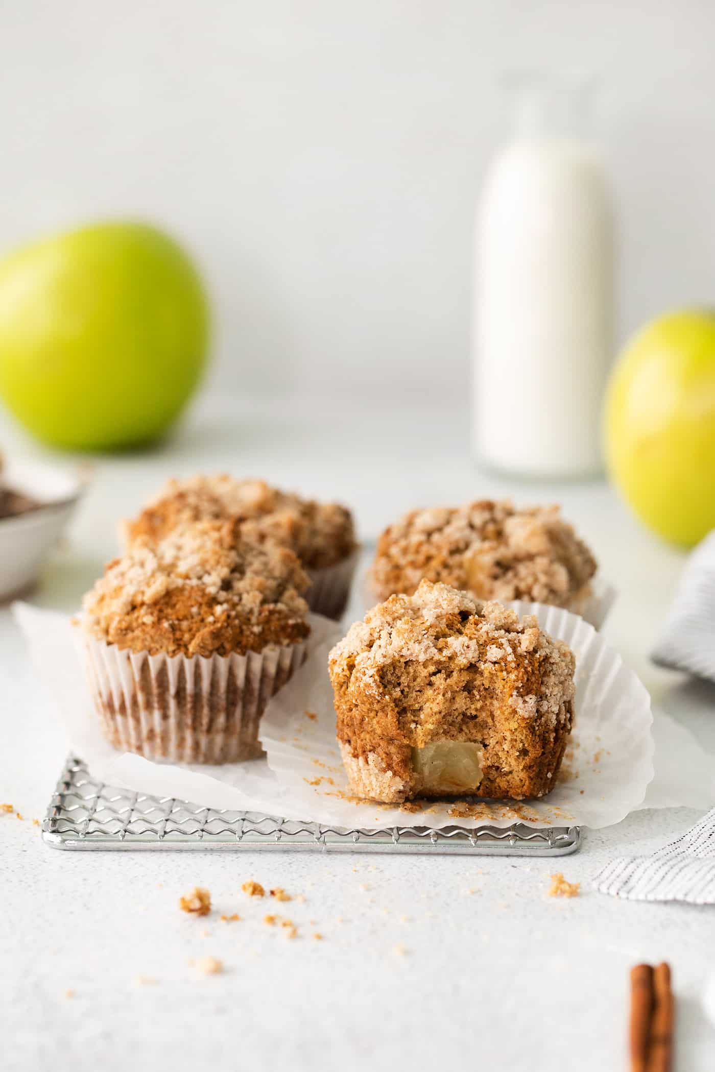 Make moist, tender apple muffins studded with juicy apple bites! Topped with cinnamon streusel, these easy muffins are great for fall baking. Four muffins with cinnamon sugar topping