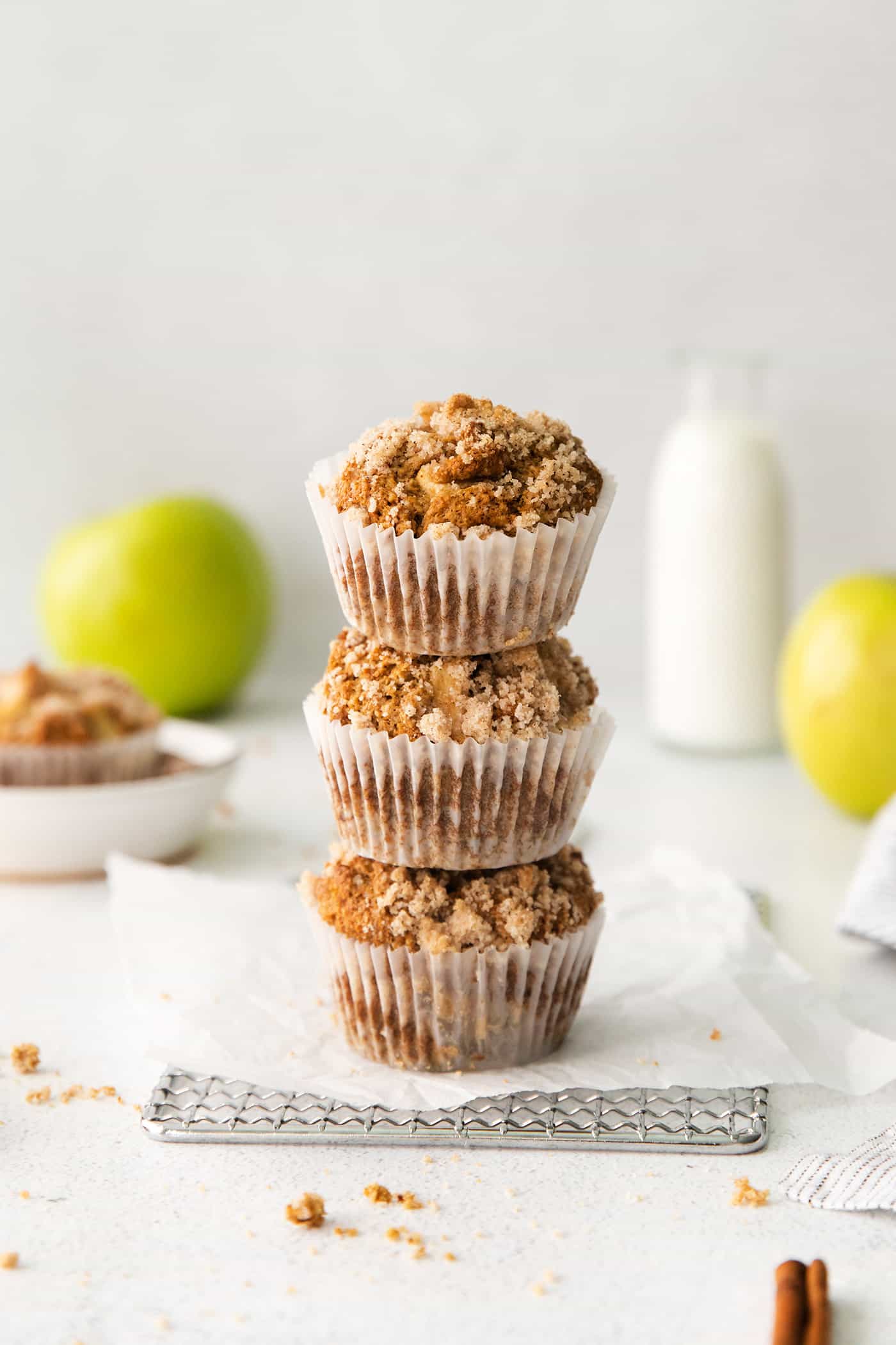 Make moist, tender apple muffins studded with juicy apple bites! Topped with cinnamon streusel, these easy muffins are great for fall baking. Three apple muffins stacked on top of each other