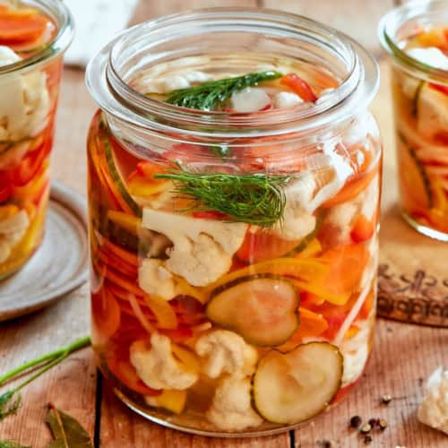Quick pickled vegetables in jar with fresh dill.