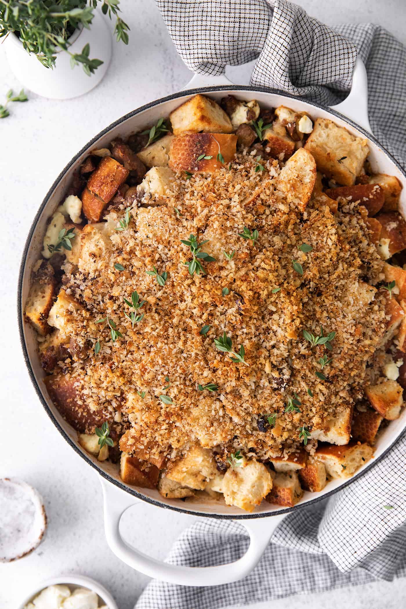 This savory dressing with mushrooms, pork sausage, crispy garlic breadcrumbs, and Parmesan is the best Thanksgiving stuffing recipe! A white casserole dish of dressing with mushrooms, garlic, sausage, and herbs.