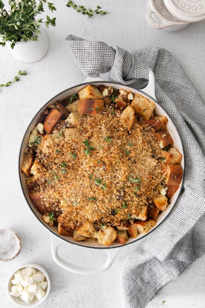 This savory dressing with mushrooms, pork sausage, crispy garlic breadcrumbs, and Parmesan is the best Thanksgiving stuffing recipe! Overhead view of mushroom sausage dressing in a casserole dish.