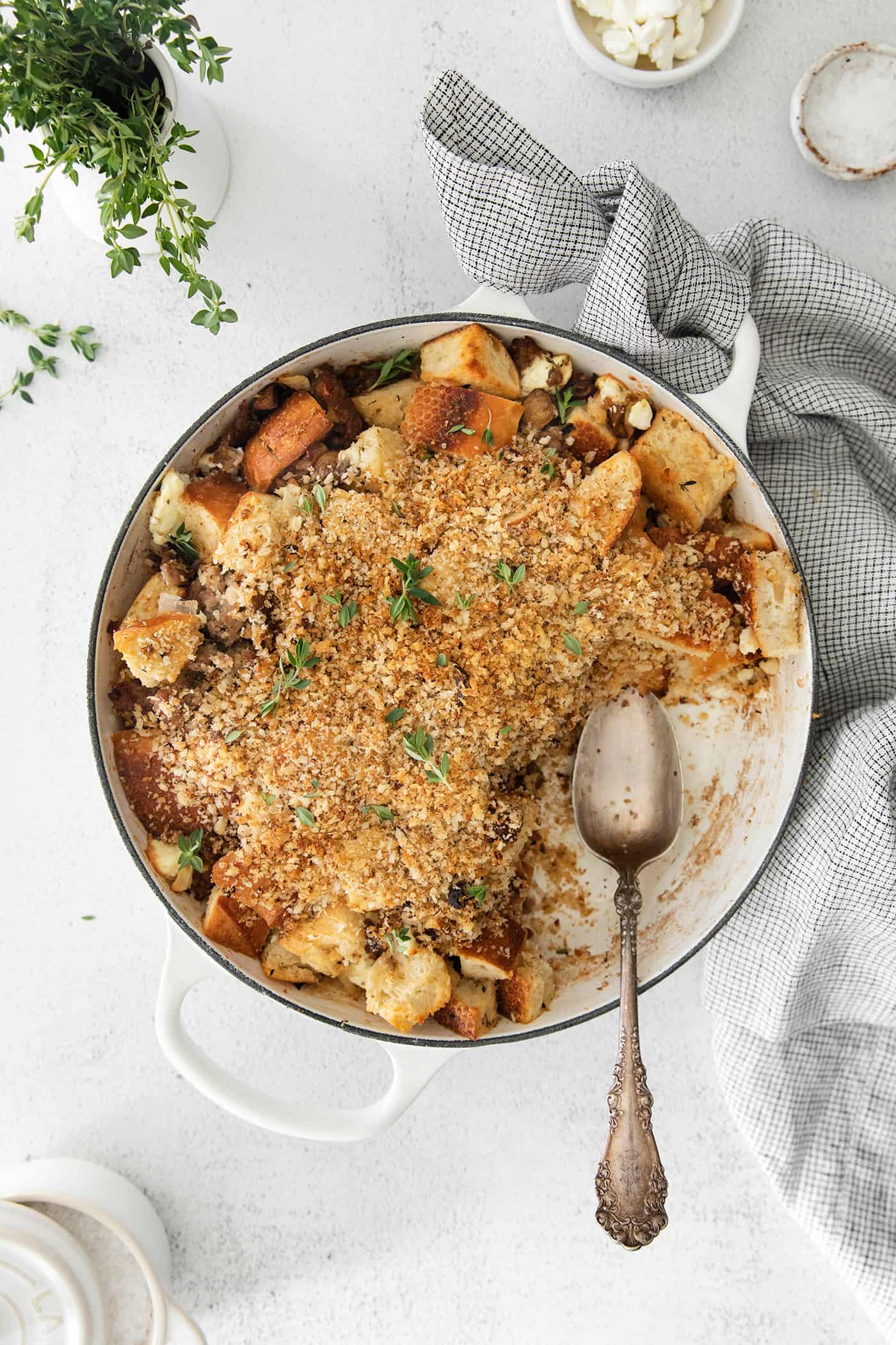 This savory dressing with mushrooms, pork sausage, crispy garlic breadcrumbs, and Parmesan is the best Thanksgiving stuffing recipe! A casserole dish of mushroom stuffing with a serving missing.