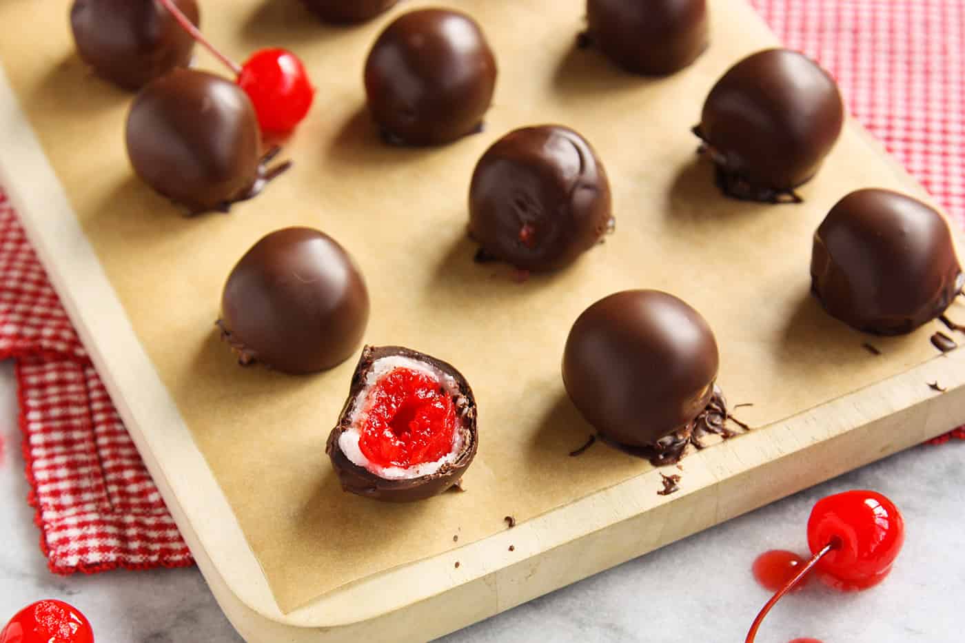 Sweet and tart, these Chocolate Covered Cherry Cordials are fun to create, even better to eat and add joy to any holiday platter. Chocolate covered cherry cordials on a baking sheet