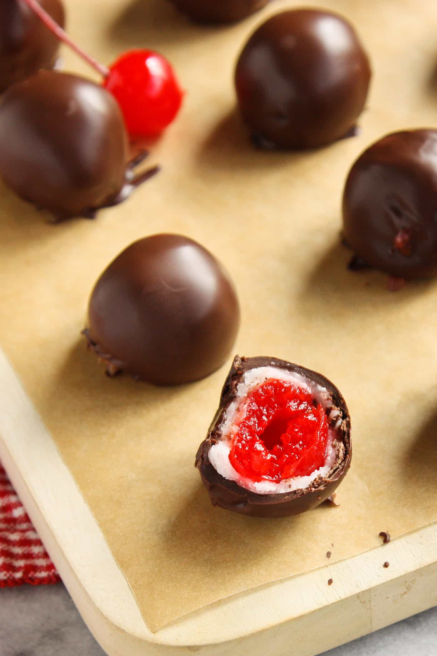 Sweet and tart, these Chocolate Covered Cherry Cordials are fun to create, even better to eat and add joy to any holiday platter. Chocolate covered cherry cordials on a baking sheet