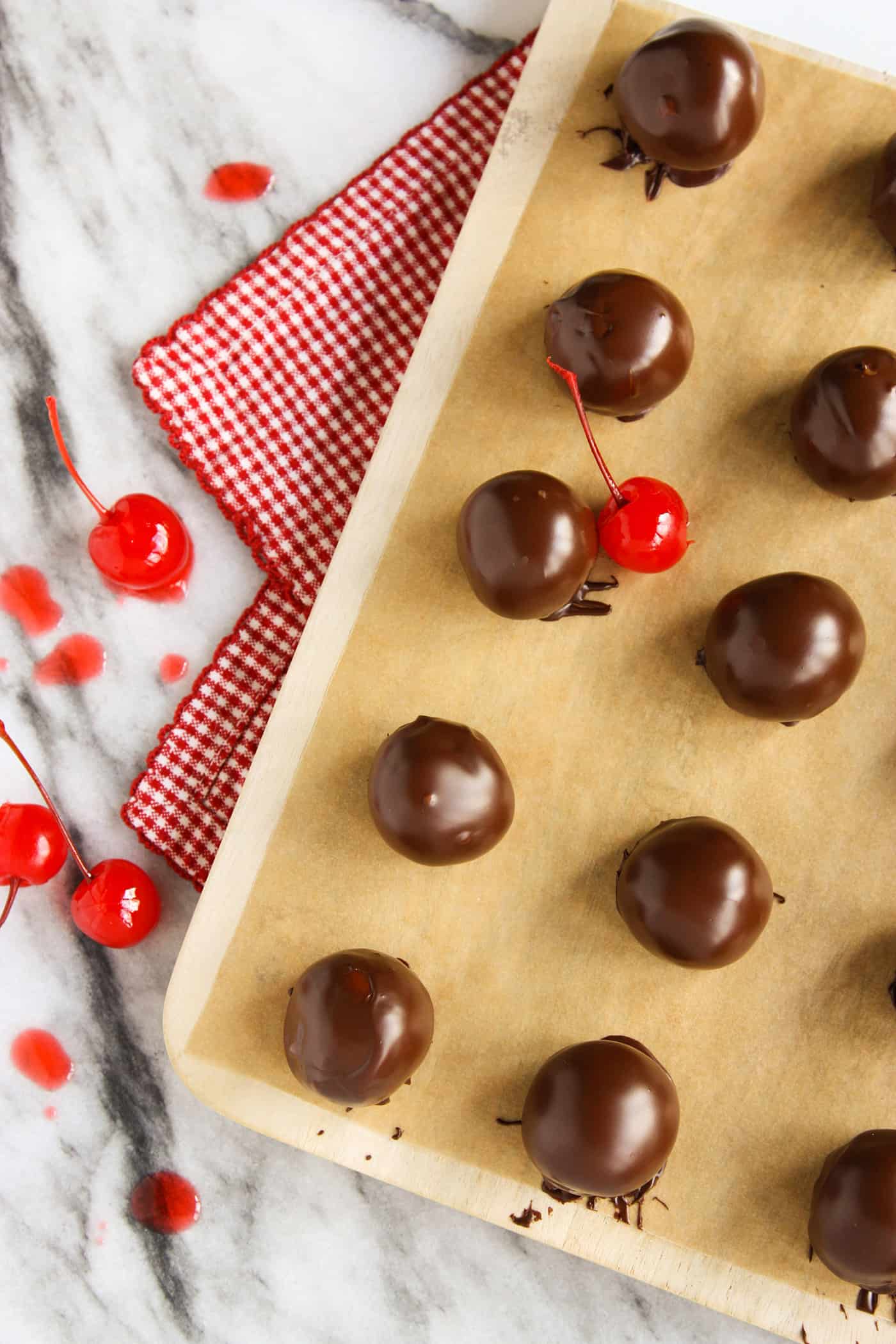 Sweet and tart, these Chocolate Covered Cherry Cordials are fun to create, even better to eat and add joy to any holiday platter. Chocolate covered cherry cordials on a baking sheet