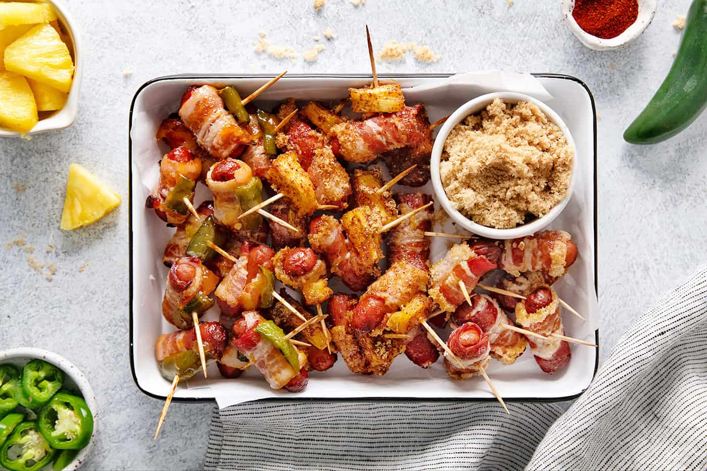 These Bacon Wrapped Smokies are the perfect game day appetizer. Switch things up by adding pineapple or jalapeno slices! Overhead view of a tray of bacon wrapped smokies