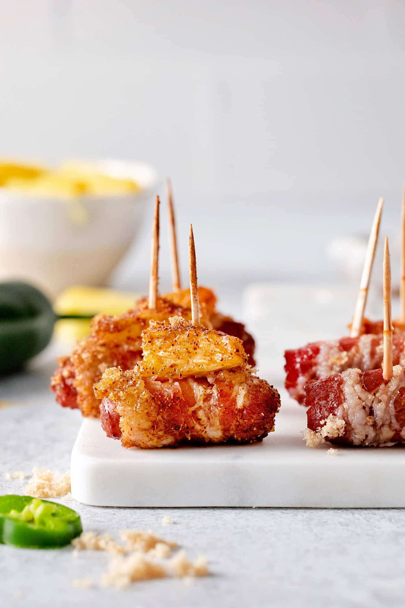 These Bacon Wrapped Smokies are the perfect game day appetizer. Switch things up by adding pineapple or jalapeno slices! Close-up of bacon wrapped smokies with pineapple