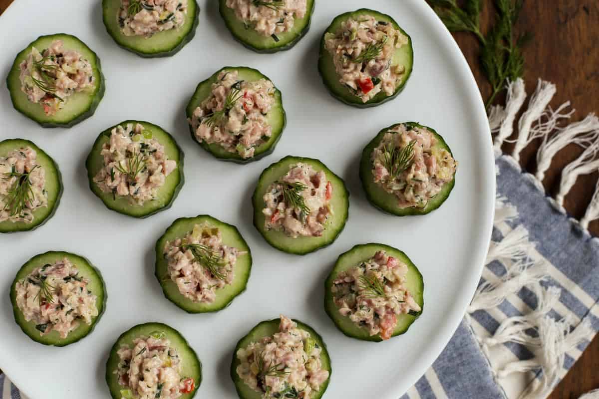 Ham Salad makes the best use of leftover ham! It's creamy and tangy, packed with crunchy vegetables, salty ham, and sweet pickle relish. Herby Ham Salad on sliced cucumber on a plate