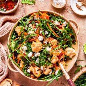 North African cauliflower salad in serving bowl with spoon.