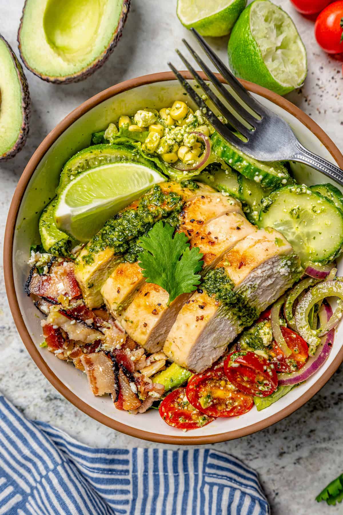 This Grilled Chicken Salad combines fresh corn, creamy avocado and juicy tomatoes with a zippy cilantro-lime vinaigrette for one tasty salad! Grilled chicken salad in bowl topped with cilantro lime vinaigrette