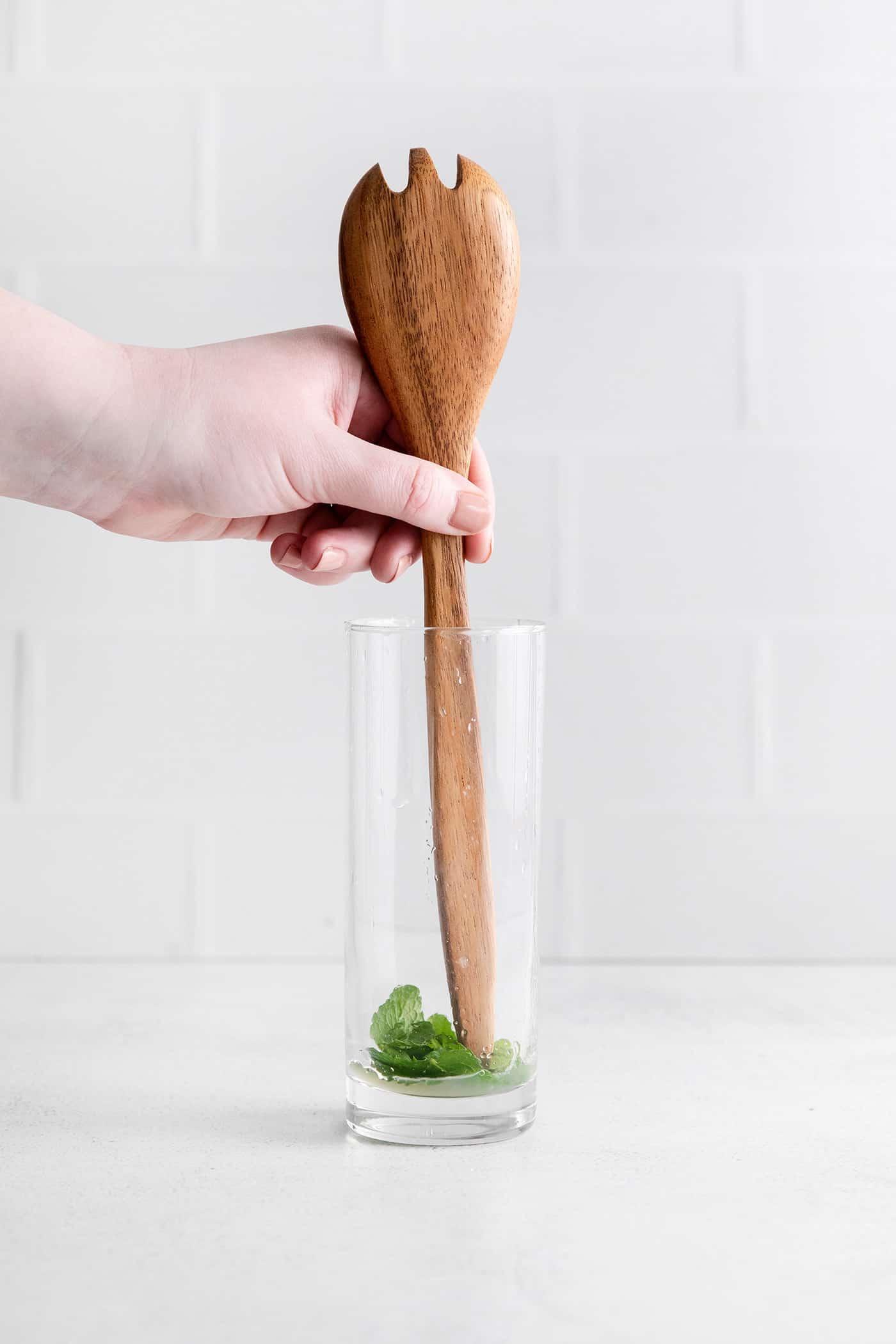 Relax by the pool this summer with a tall, cool Rhubarb Mojito. This twist on the classic cocktail is incredibly refreshing! Lime and mint being muddled with the end of a spoon