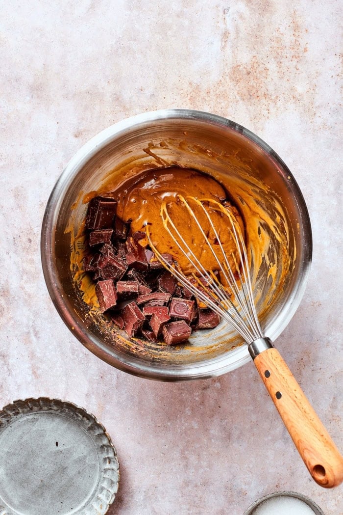 Whisk in bowl with butter, chocolate, and egg yolks.