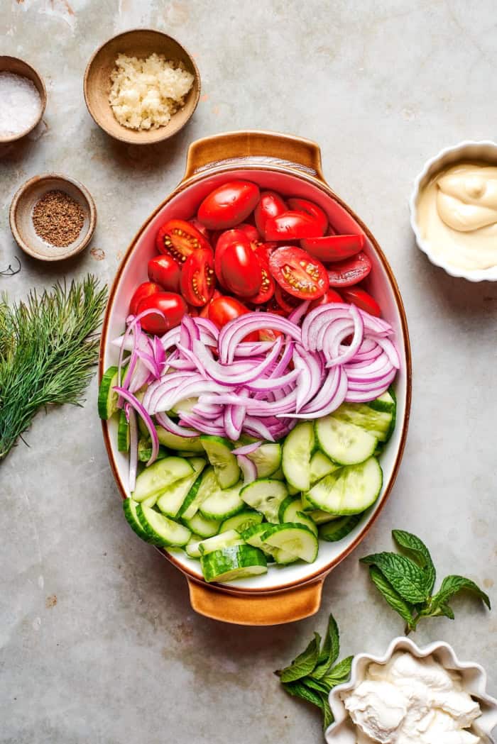 Tomatoes, red onion, and cucumber in bowl.