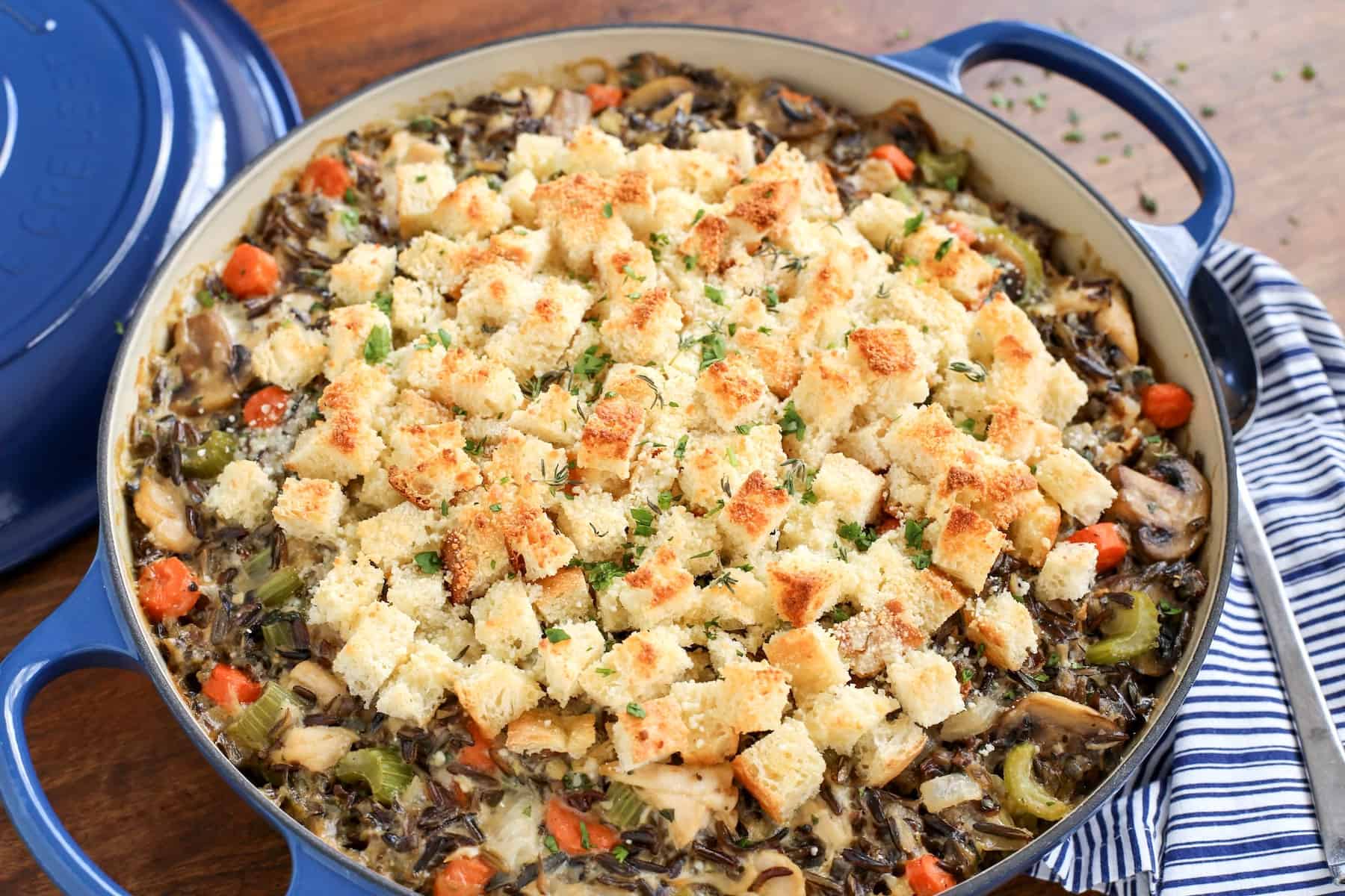 This creamy chicken wild rice casserole is easy comfort food loaded with veggies, melty gruyere cheese, and a buttery crouton topping! Chicken wild rice casserole with gruyere cheese