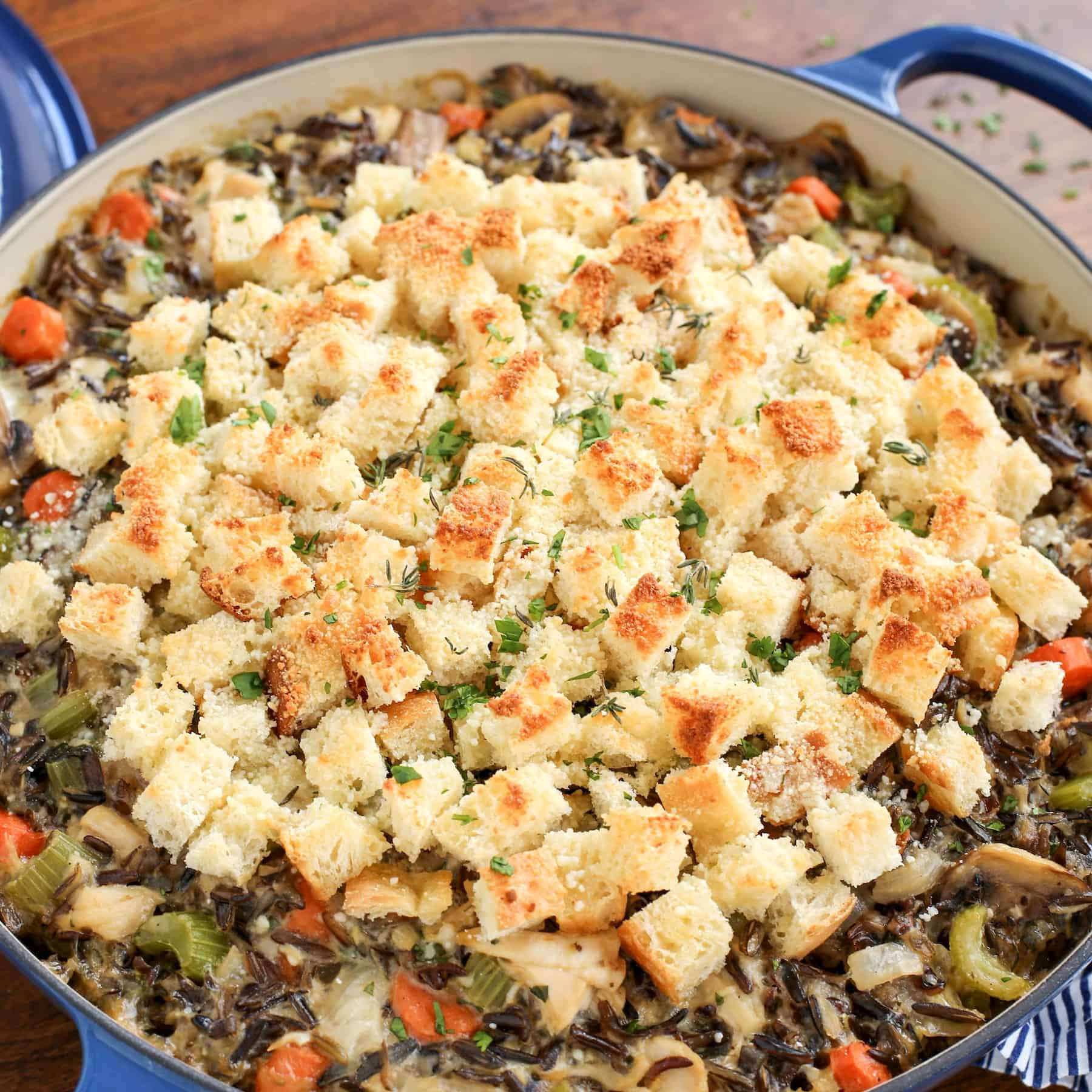 This creamy chicken wild rice casserole is easy comfort food loaded with veggies, melty gruyere cheese, and a buttery crouton topping! Chicken wild rice casserole topped with homemade croutons