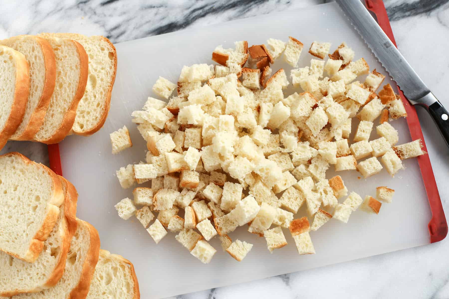 This creamy chicken wild rice casserole is easy comfort food loaded with veggies, melty gruyere cheese, and a buttery crouton topping! Homemade croutons on a cutting board