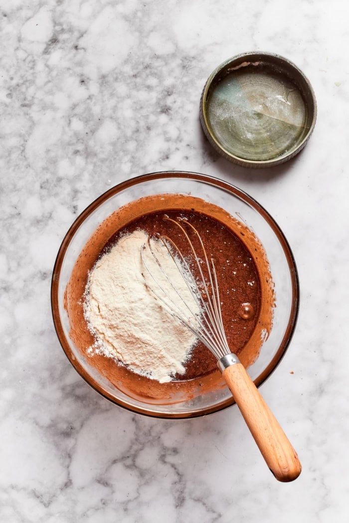 These Nutella cheesecake bars top a fudgy brownie base with creamy Nutella cheesecake for a rich, decadent dessert that’s surprisingly easy! Whisk in bowl with flour and wet ingredients for brownies.