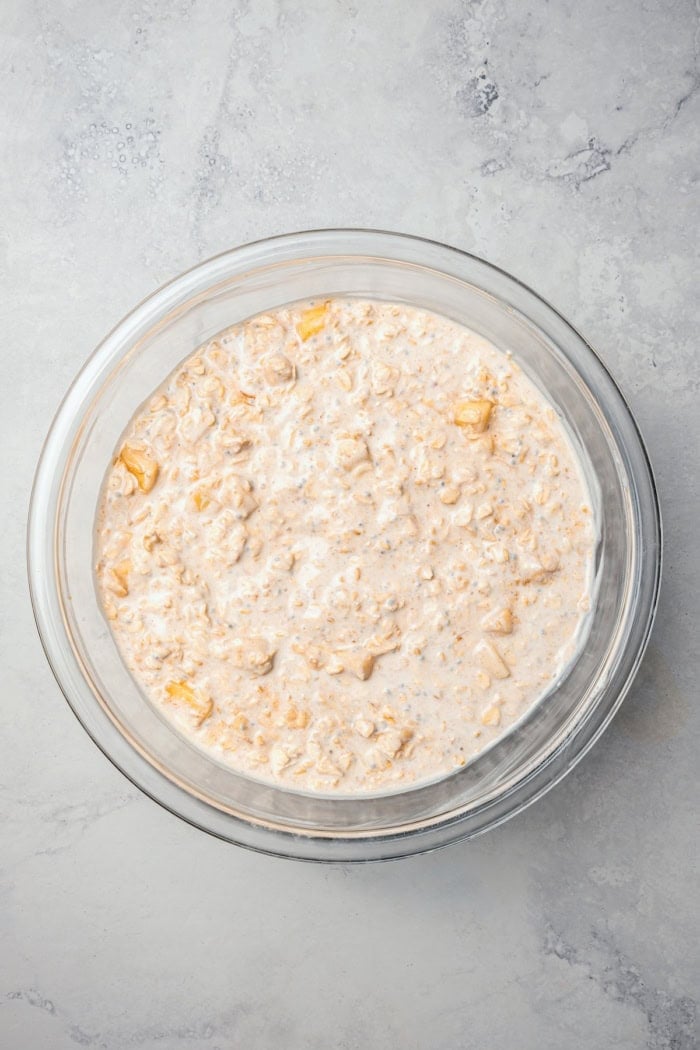 This Apple Cinnamon Overnight Oats recipe is an easy make-ahead breakfast, with the creamiest oats and lots of cozy, tender apples! Overhead view of overnight oats in mixing bowl before chilling