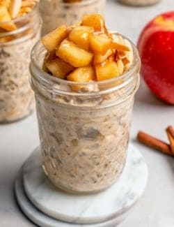 Jar of overnight oats topped with cinnamon apples