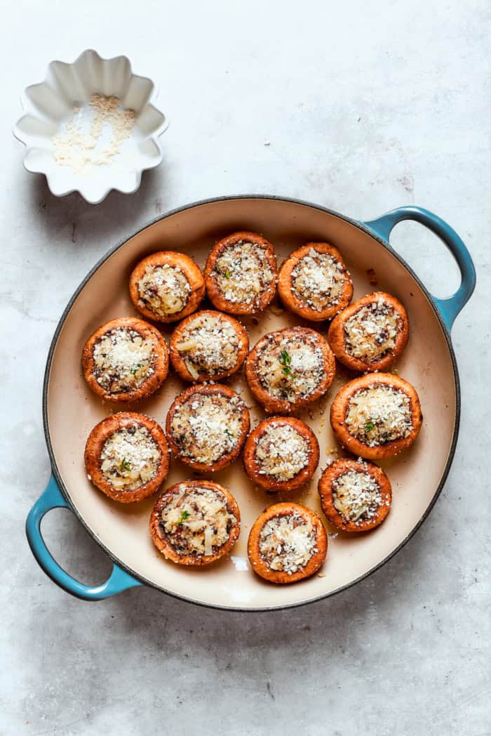 These easy Cheesy Stuffed Mushrooms are an irresistible appetizer or side dish, with lots of melty cheese and garlicky breadcrumbs. Yum! Overhead view of cheesy stuffed mushrooms in skillet