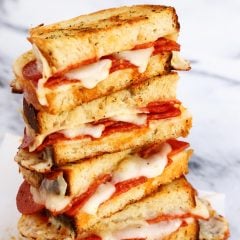 A stack of pepperoni pizza grilled cheese halves.