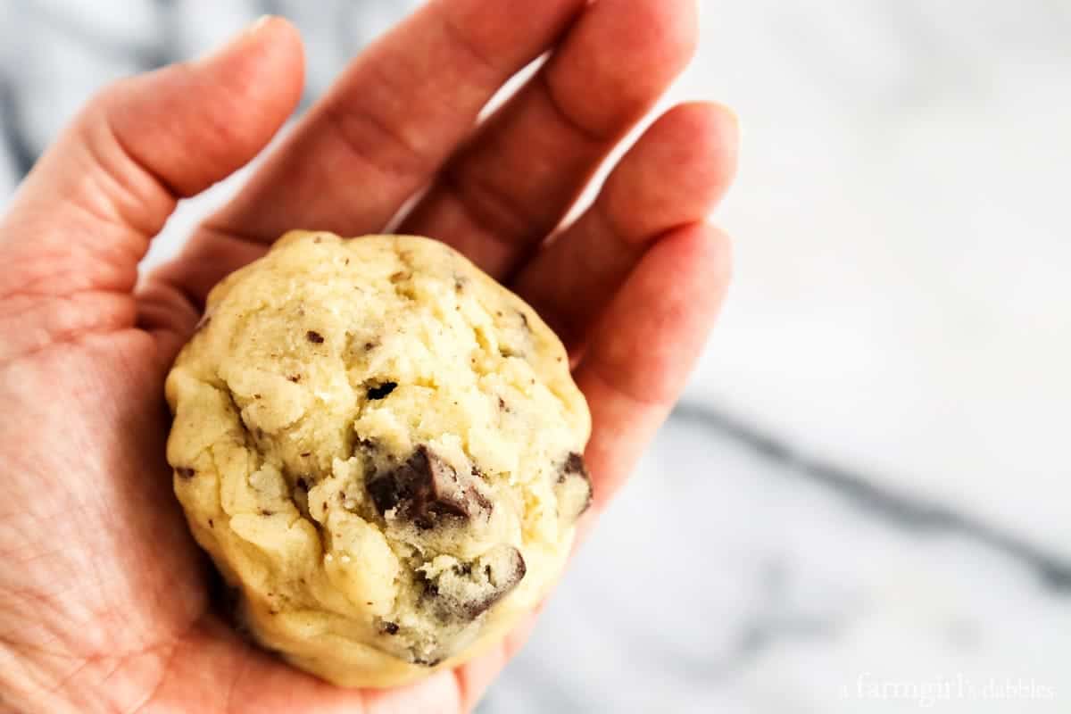 a ball of cookie dough in the palm of a hand