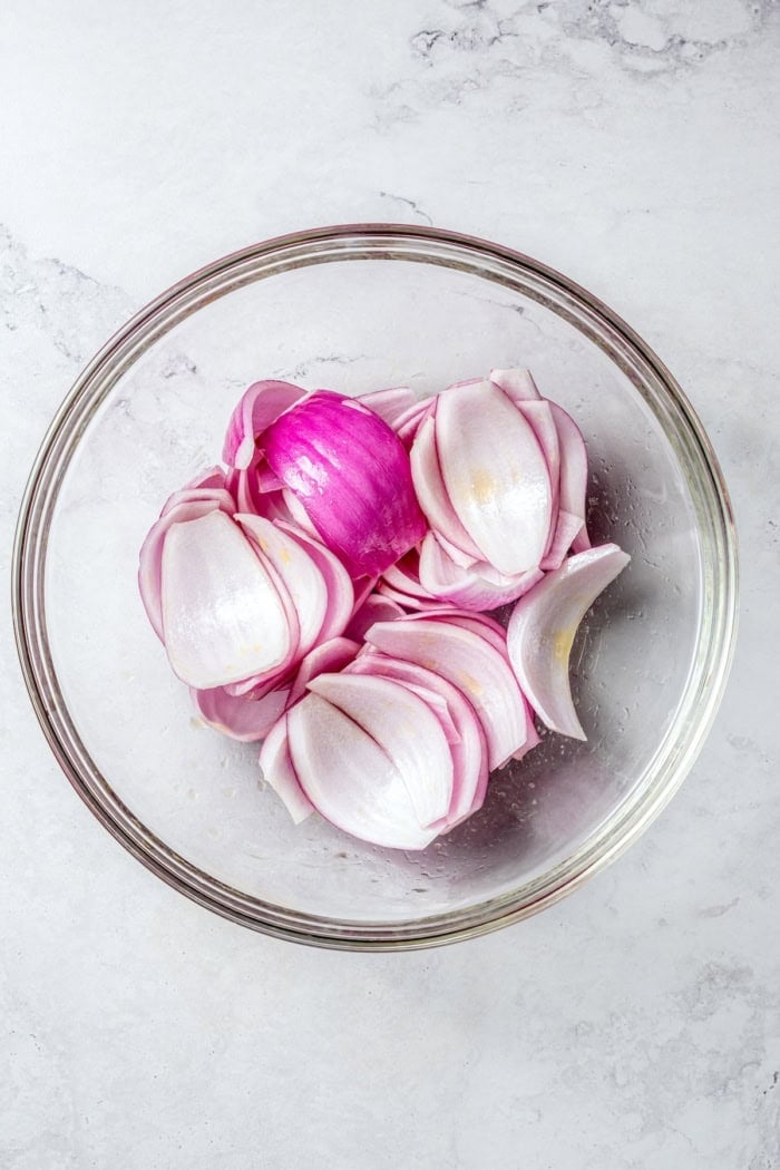 Bold, smoky chipotle meets the sweet flavor of orange in these easy Turkey Kabobs. This recipe is a summer staple in my home! Overhead view of red onions in bowl with oil
