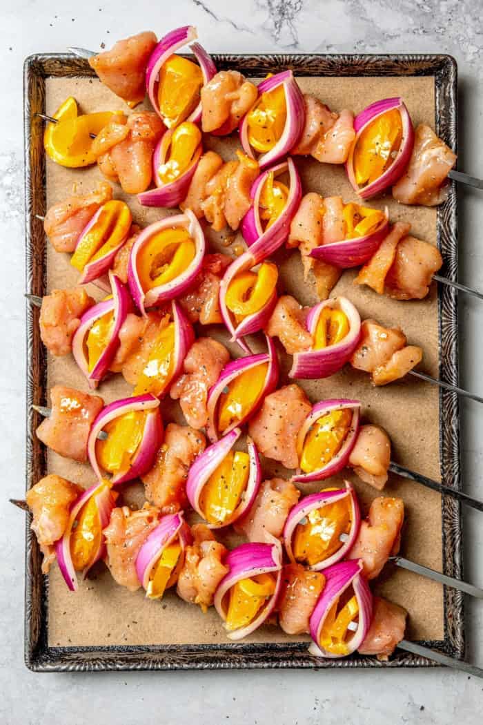 Bold, smoky chipotle meets the sweet flavor of orange in these easy Turkey Kabobs. This recipe is a summer staple in my home! Overhead view of uncooked turkey kabobs on sheet pan