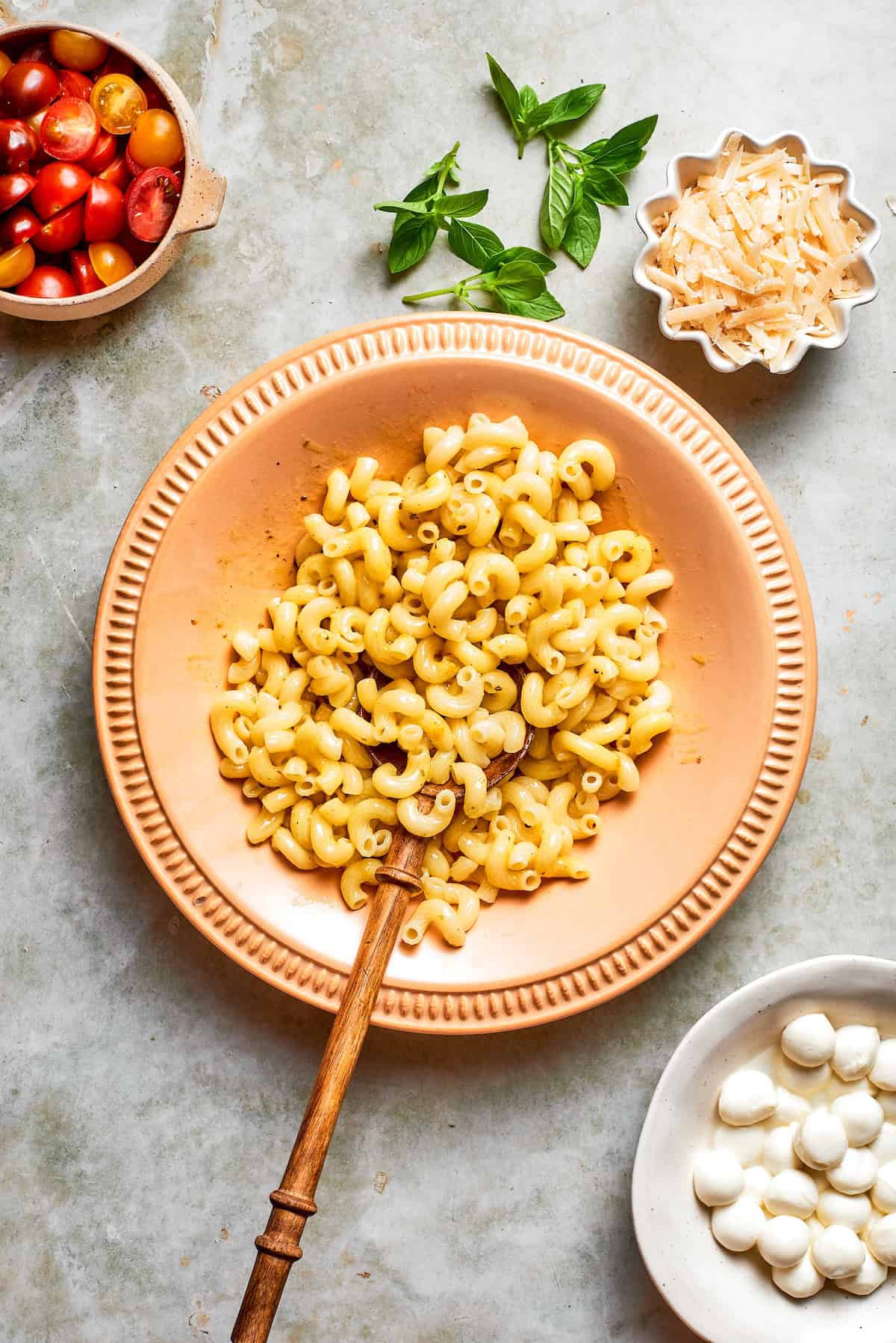 Pasta added to bowl with vinaigrette.