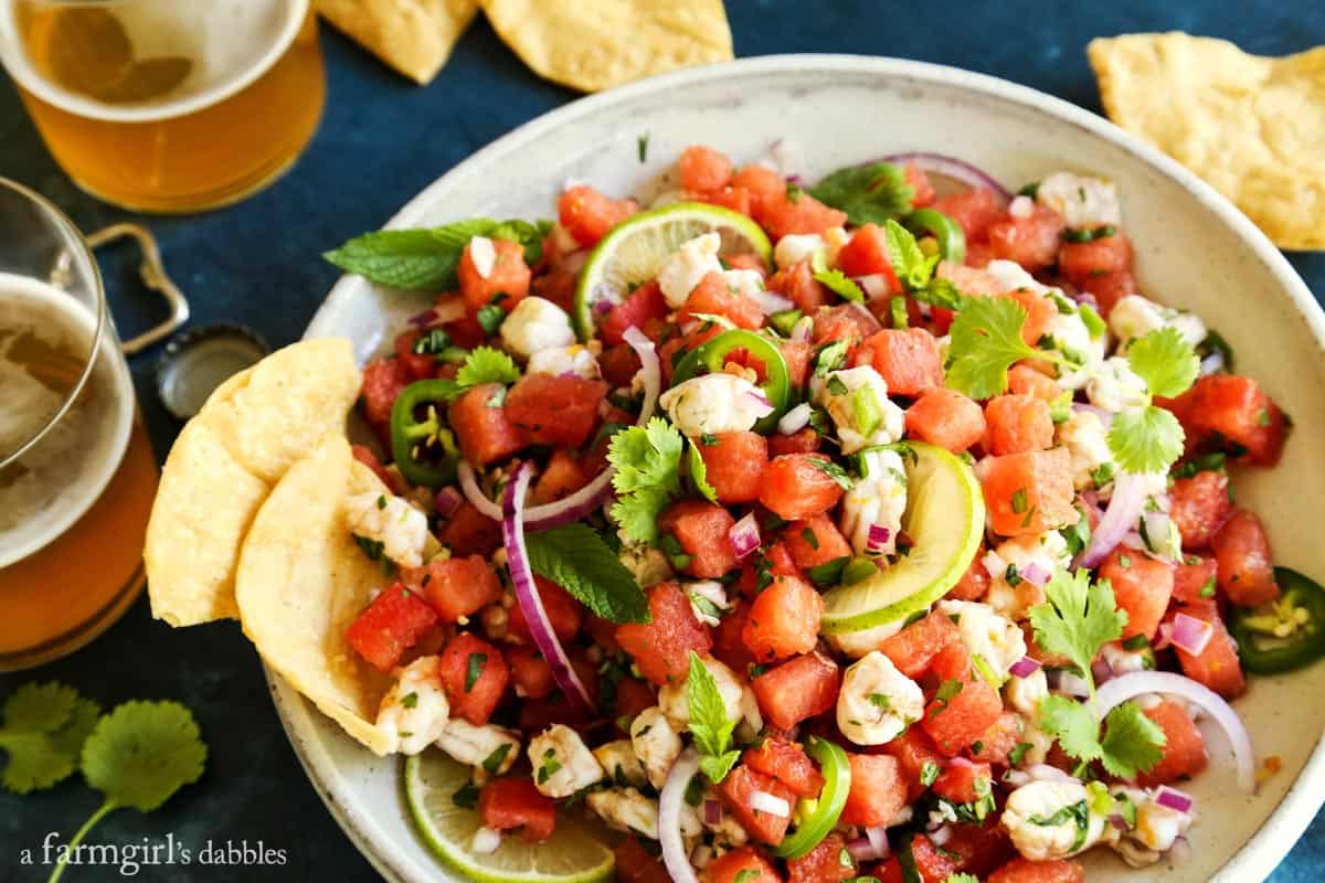 This watermelon and citrus shrimp ceviche recipe is loaded with nuggets of fresh shrimp, plus the bright flavors of orange and lime! ceviche, chips, and two glasses of beer