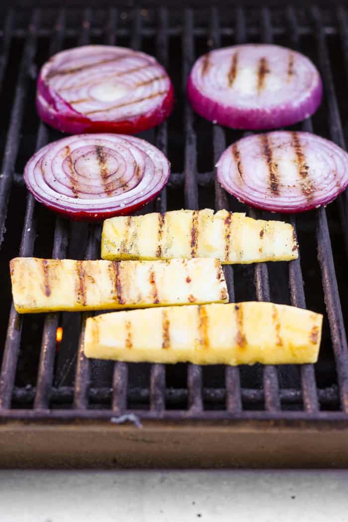 This Grilled Pork and Pineapple Tacos recipe a much easier twist on tacos al pastor. It promises to be your next taco night hit! Pineapple spears and red onion rounds on grill