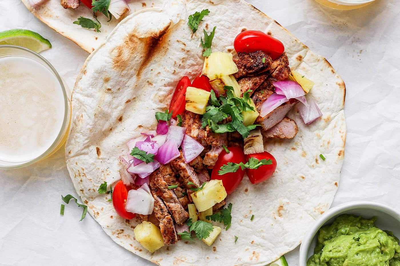 This Grilled Pork and Pineapple Tacos recipe a much easier twist on tacos al pastor. It promises to be your next taco night hit! Overhead view of grilled pork and pineapple taco before folding