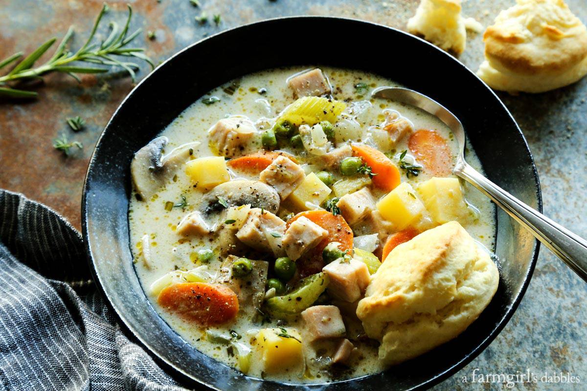 Smoked Turkey Pot Pie Soup is full of rich flavors and creamy comfort, and served with ultra-tender cream biscuits for dipping! a bowl of Smoked Turkey Pot Pie Soup