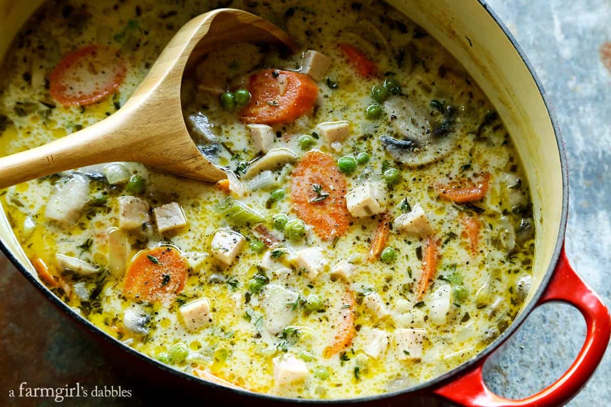 Smoked Turkey Pot Pie Soup is full of rich flavors and creamy comfort, and served with ultra-tender cream biscuits for dipping! Smoked Turkey Pot Pie Soup in a red pot