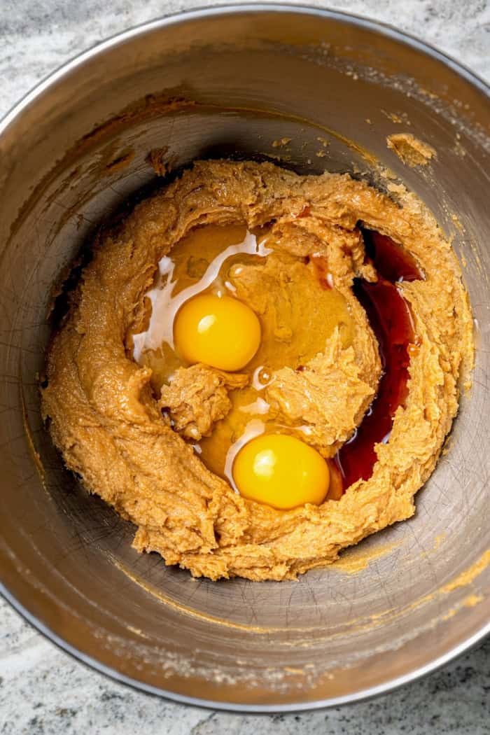 These soft, chewy peanut butter chocolate chip cookies are extra wonderful with three kinds of chocolate, plus a sprinkle of sea salt! Eggs and vanilla added to bowl of creamed butter and sugar.