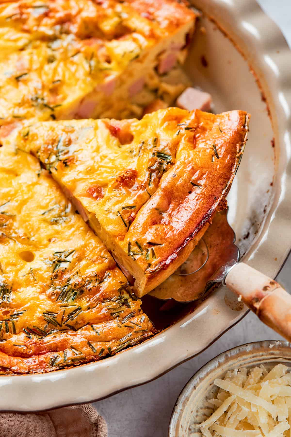 A slice of golden, baked ham quiche with no crust.