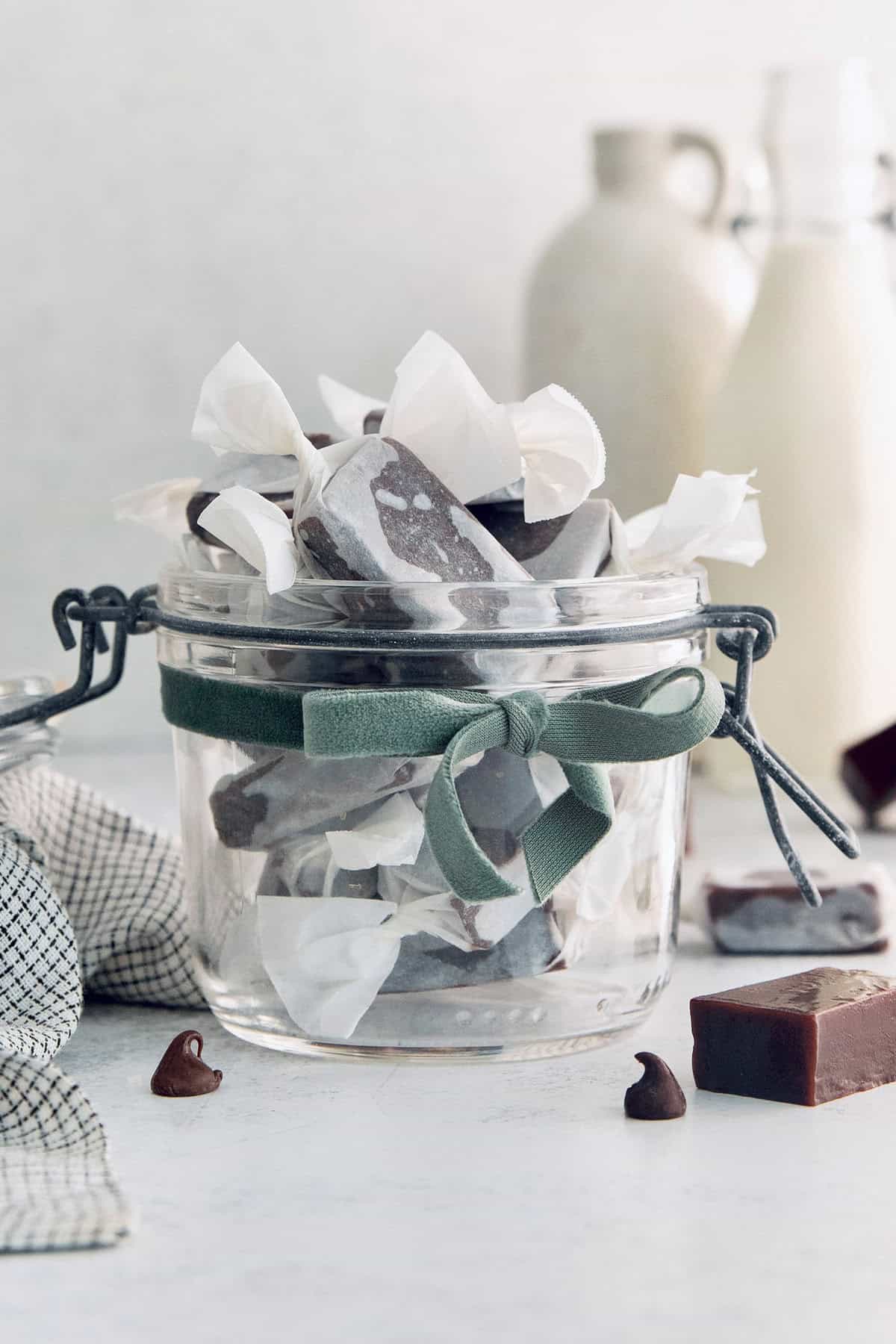 A glass jar full of individually-wrapped caramels. 