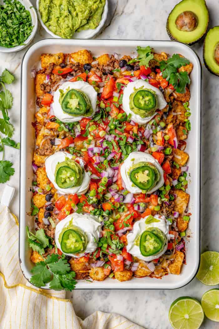 Overhead view of sheet pan of totchos with toppings