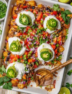 Overhead view of totchos in pan with wooden serving spoon