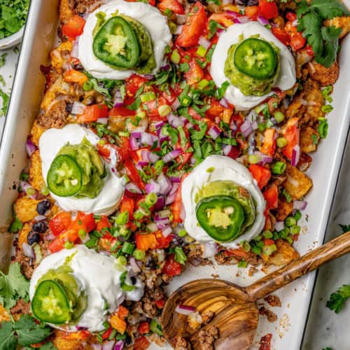 Overhead view of totchos in pan with wooden serving spoon