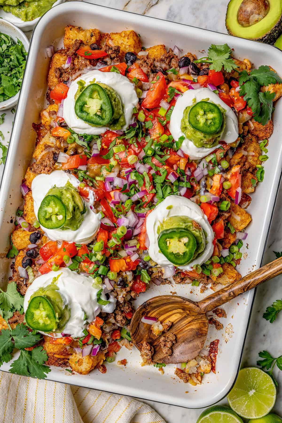 Overhead view of totchos in pan with wooden serving spoon
