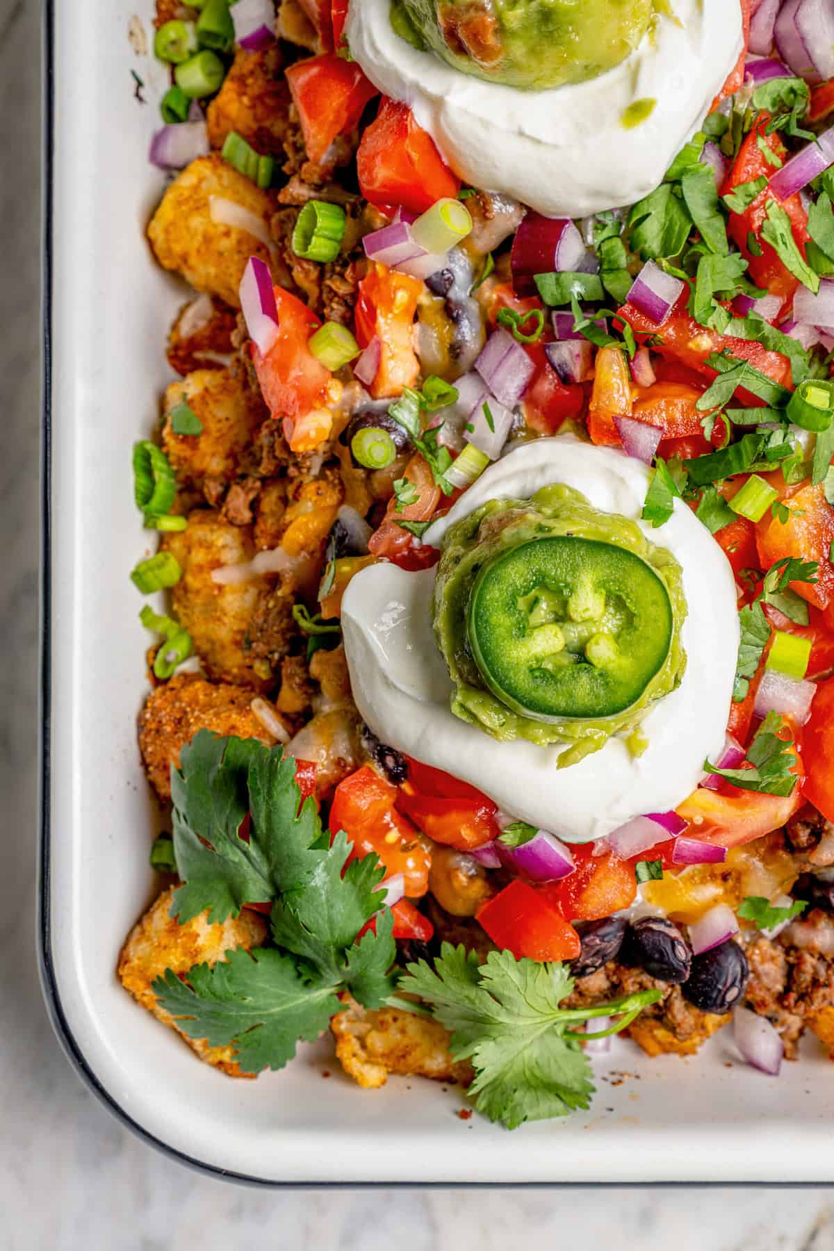 Overhead view of totchos on pan with toppings